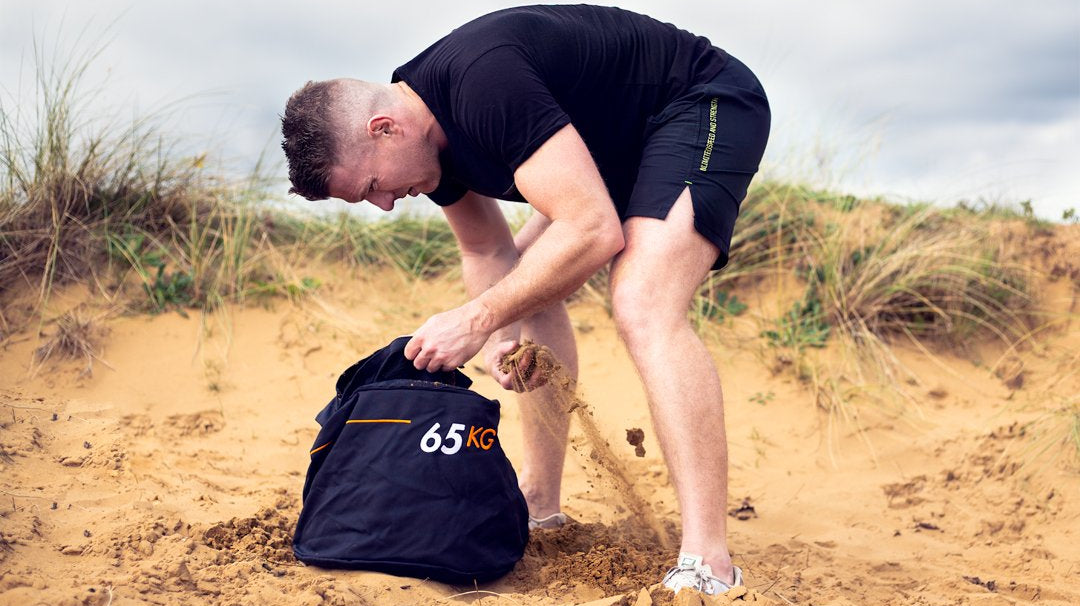 Athlete filling their Strongman Sandbag